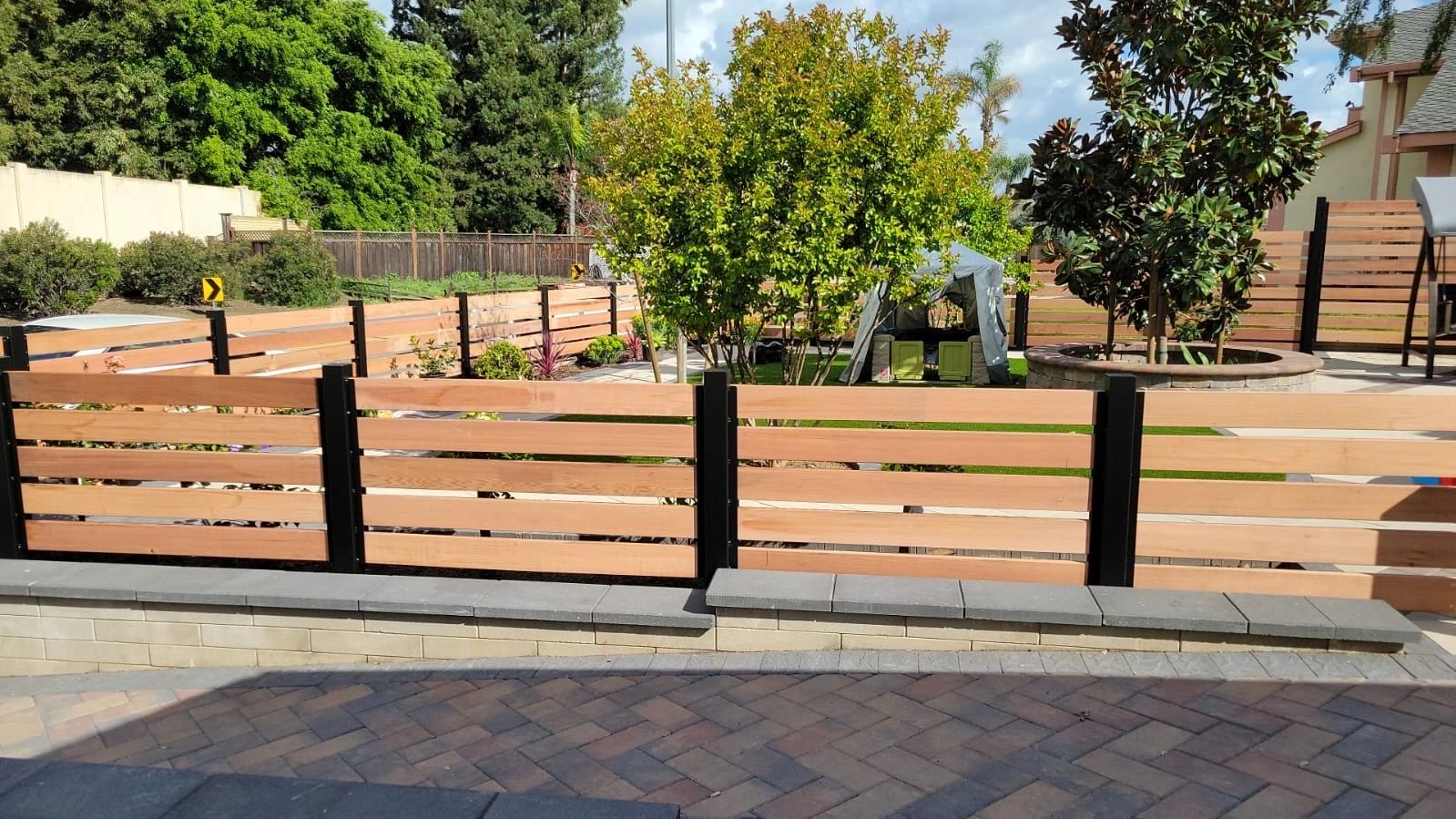 Modern wood front yard fence with black metal posts