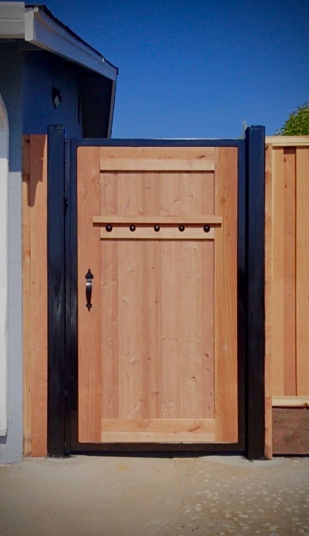 Metal-framed wood gate installed alongside a matching fence line