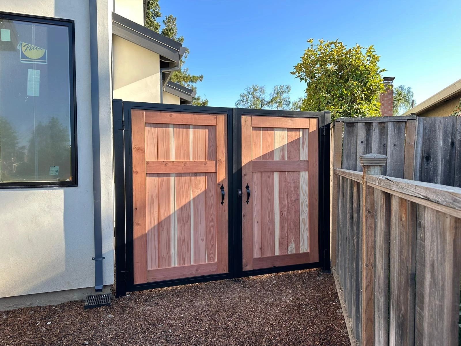 Residential wood gate built on a black metal frame structure